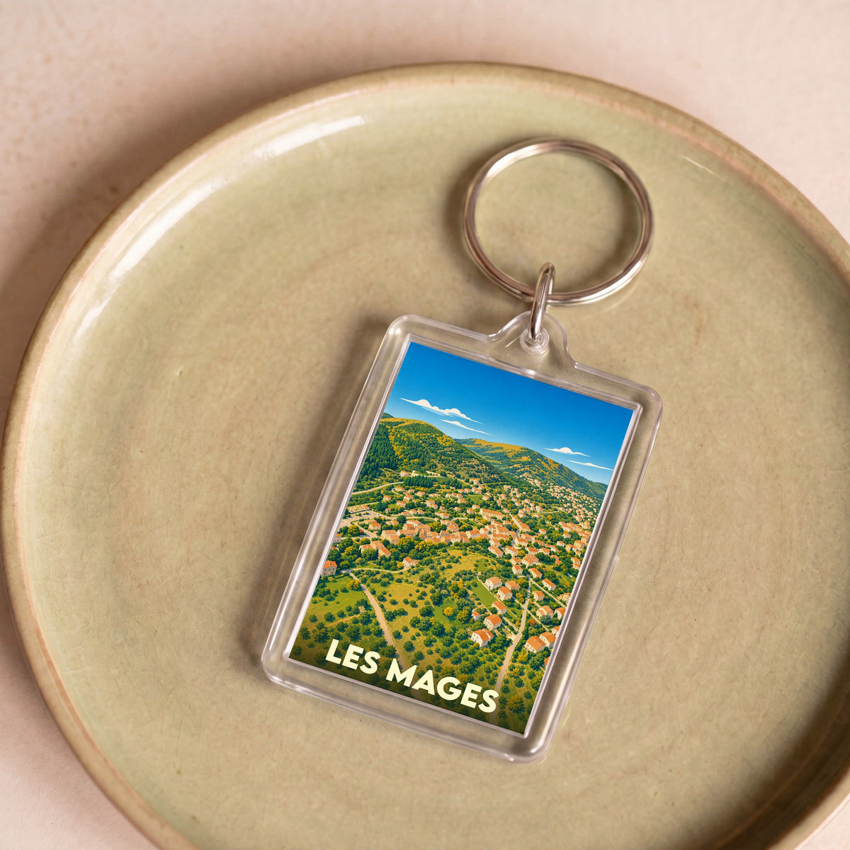 Porte-clés souvenir de la ville de Les Mages avec une illustration aérienne stylisée.