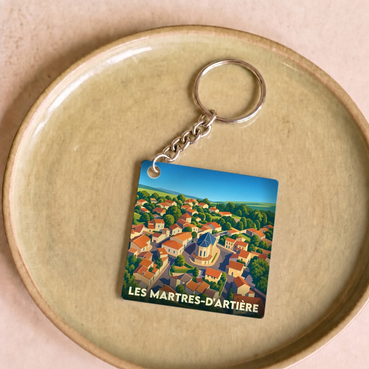 Porte-clés souvenir de la ville de Les Martres-d'Artière avec une illustration stylisée.
