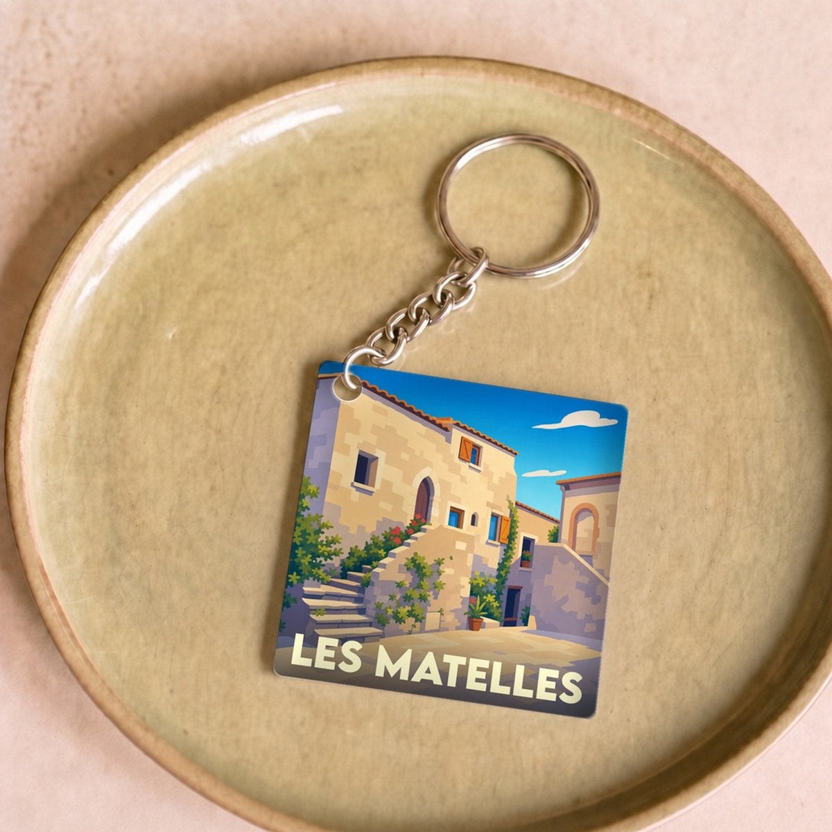 Porte-clés souvenir de la ville de Les Matelles avec une illustration stylisée.