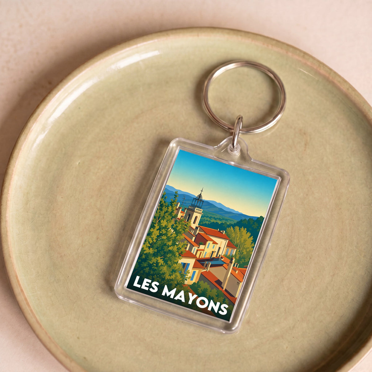 Porte-clés souvenir de la ville de Les Mayons avec une illustration stylisée.