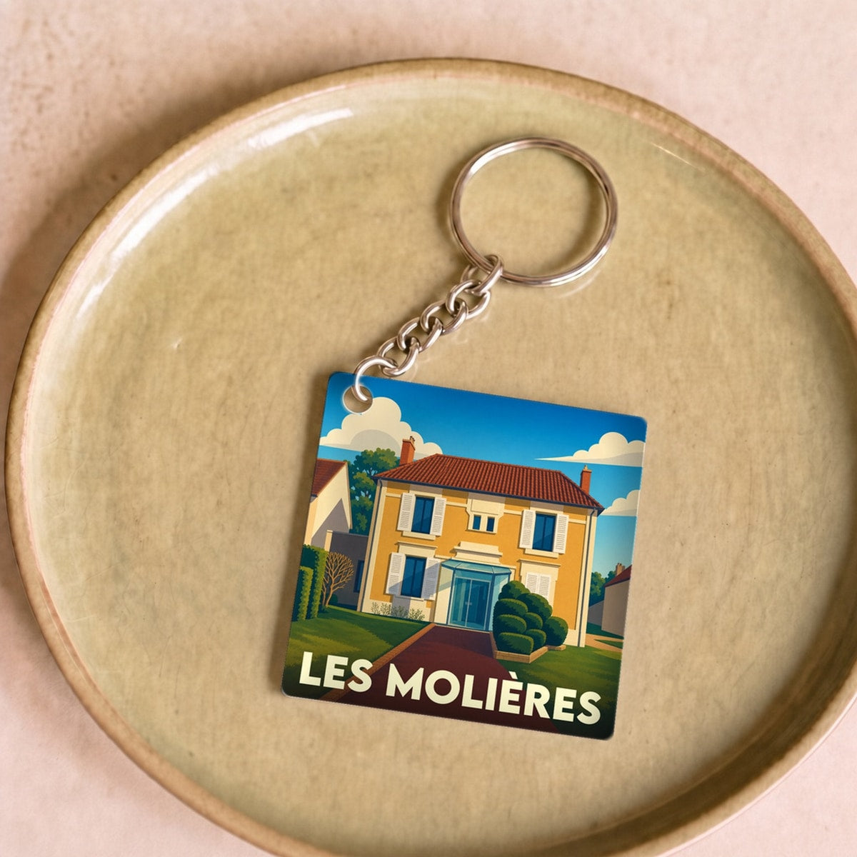Porte-clés souvenir de la ville de Les Molières avec une illustration stylisée d'une maison.