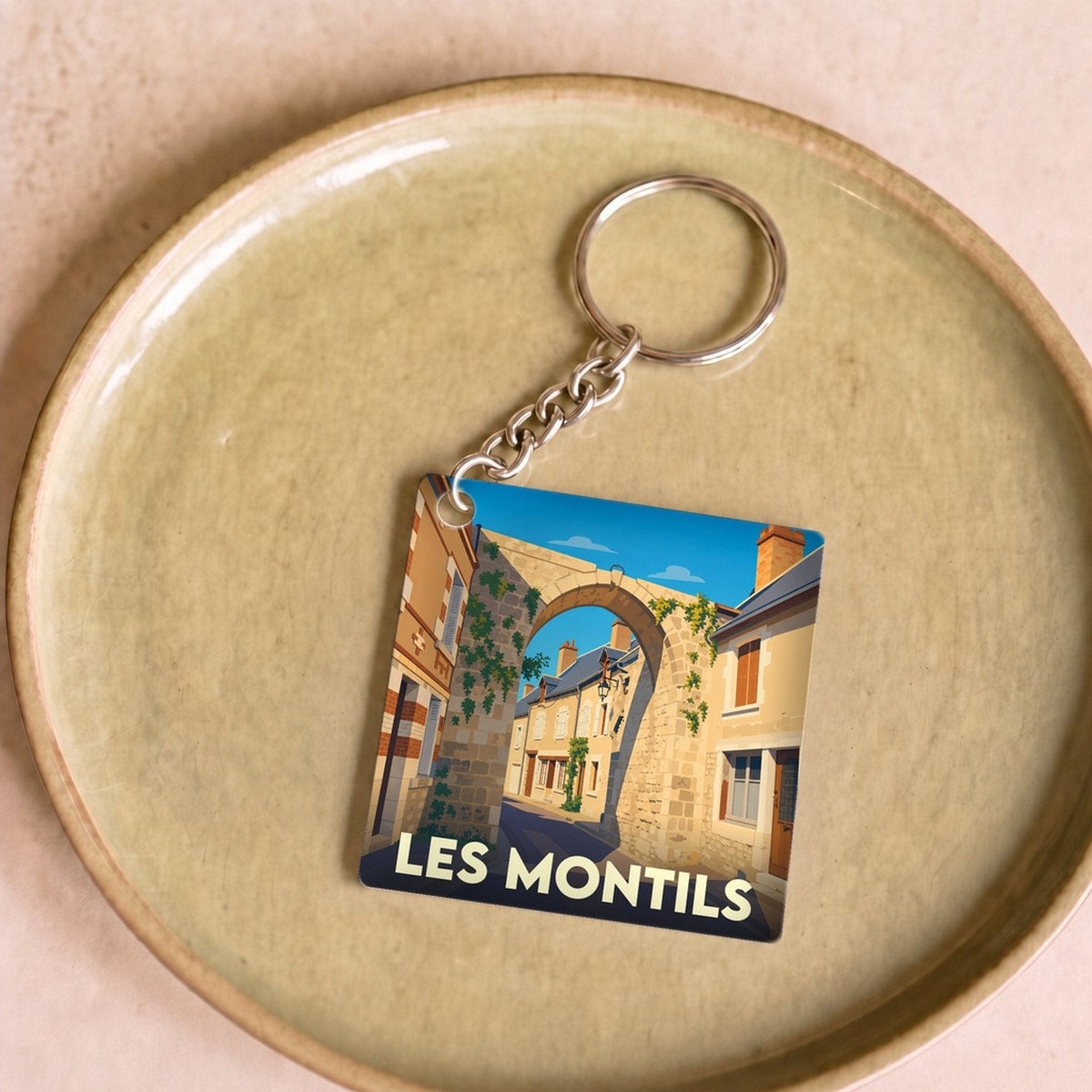 Porte-clés souvenir de la ville de Les Montils avec une illustration stylisée.