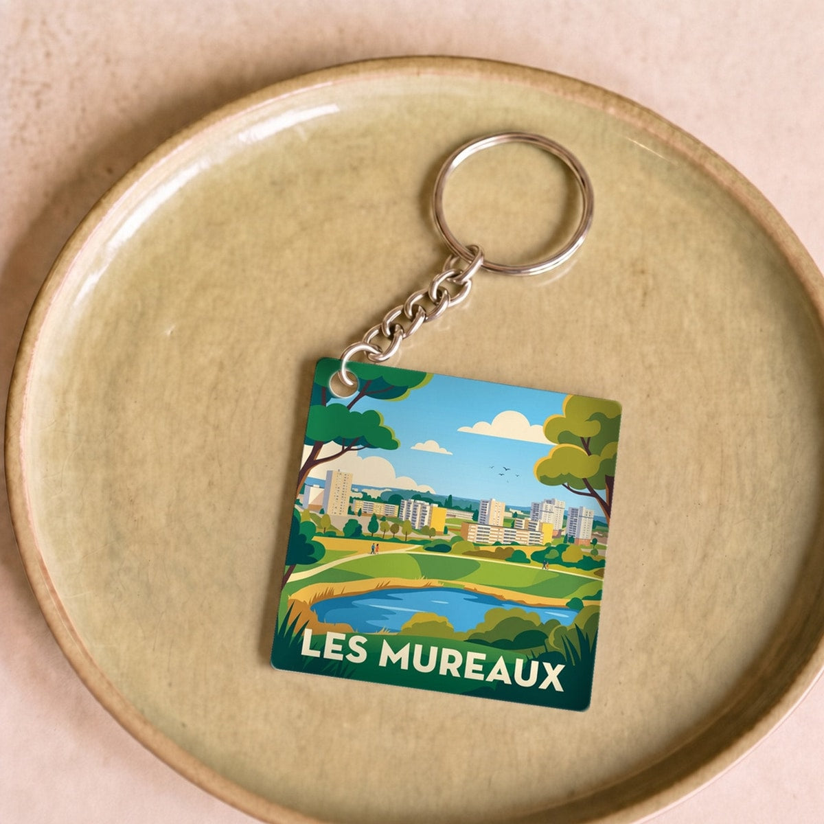 Porte-clés souvenir de la ville de Les Mureaux avec une illustration stylisée.