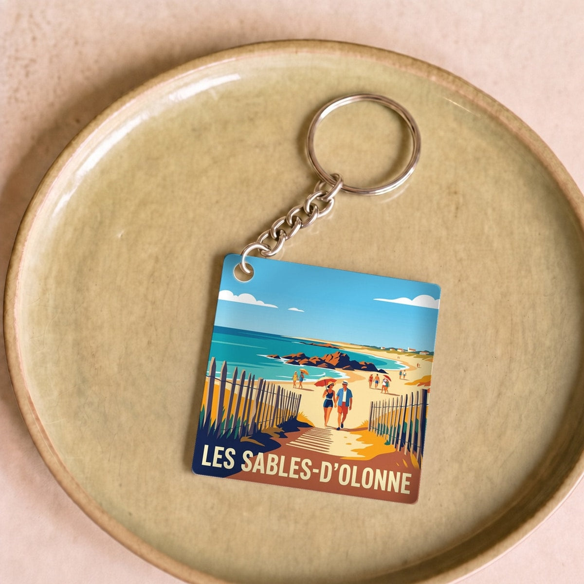 Porte-clés souvenir de la ville de Les Sables-d'Olonne avec une illustration de plage stylisée.