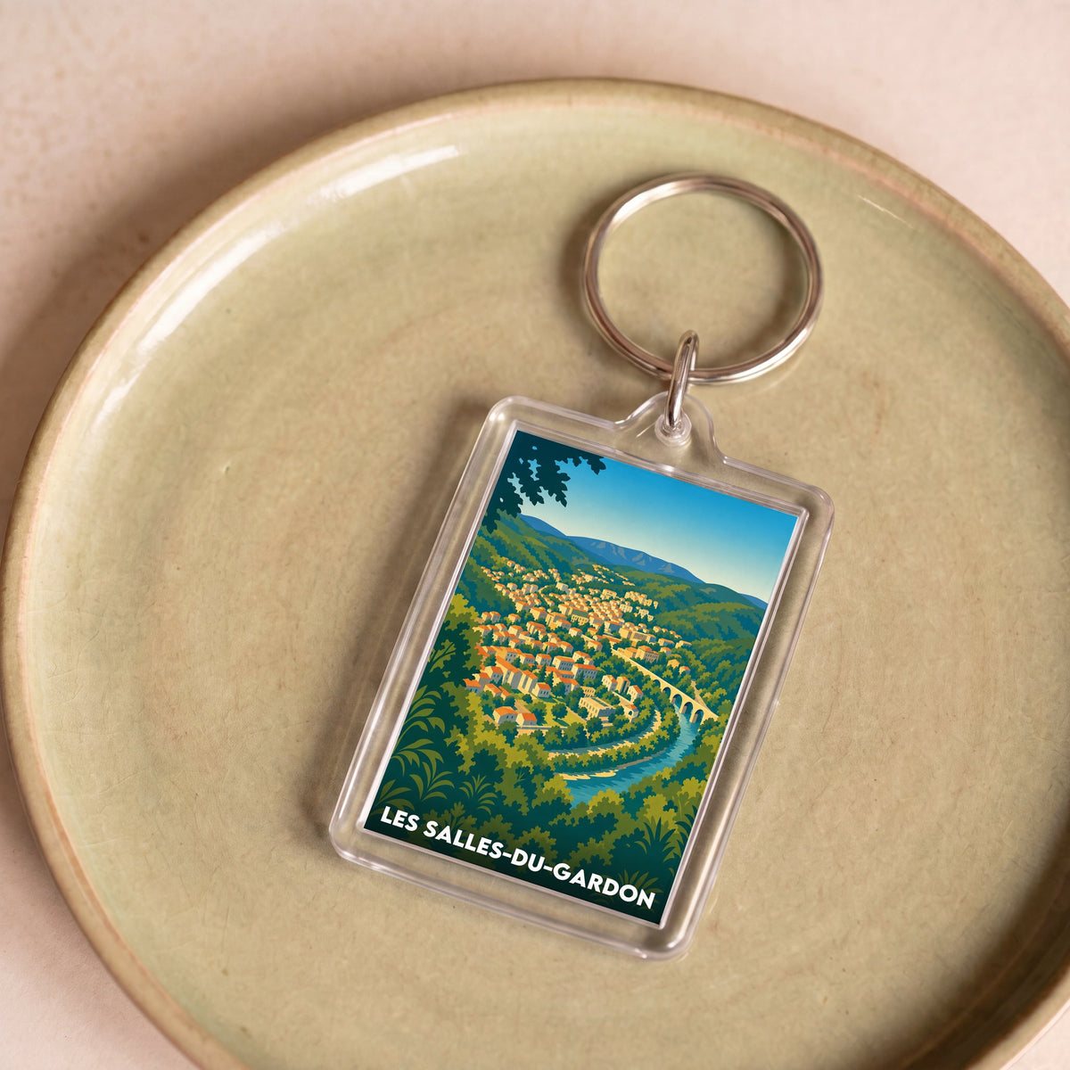 Porte-clés souvenir de la ville de Les Salles-du-Gardon avec une illustration stylisée de son paysage.