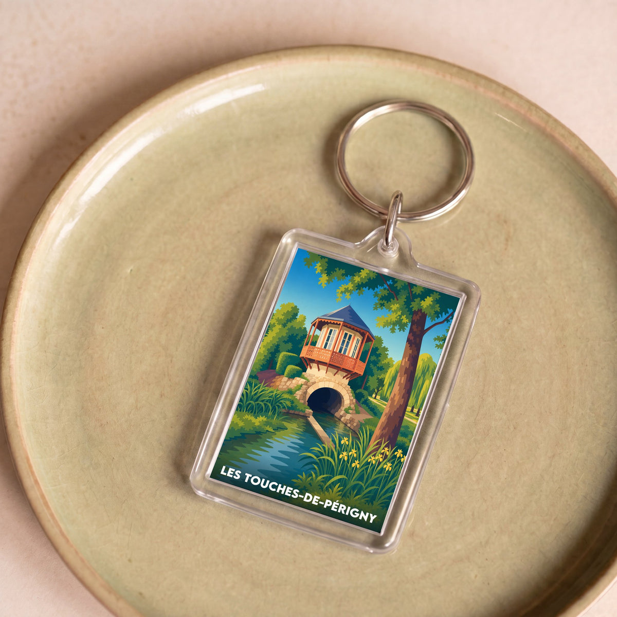 Porte-clés souvenir de la ville de Les Touches-de-Périgny avec une illustration stylisée d'un paysage local.