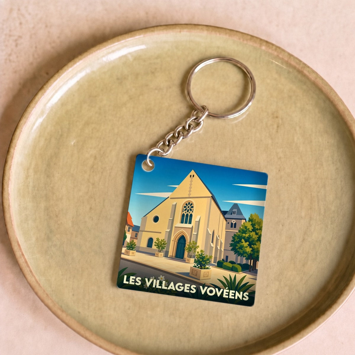 Porte-clés souvenir de la ville de Les Villages Vovéens avec une illustration stylisée d'une église.