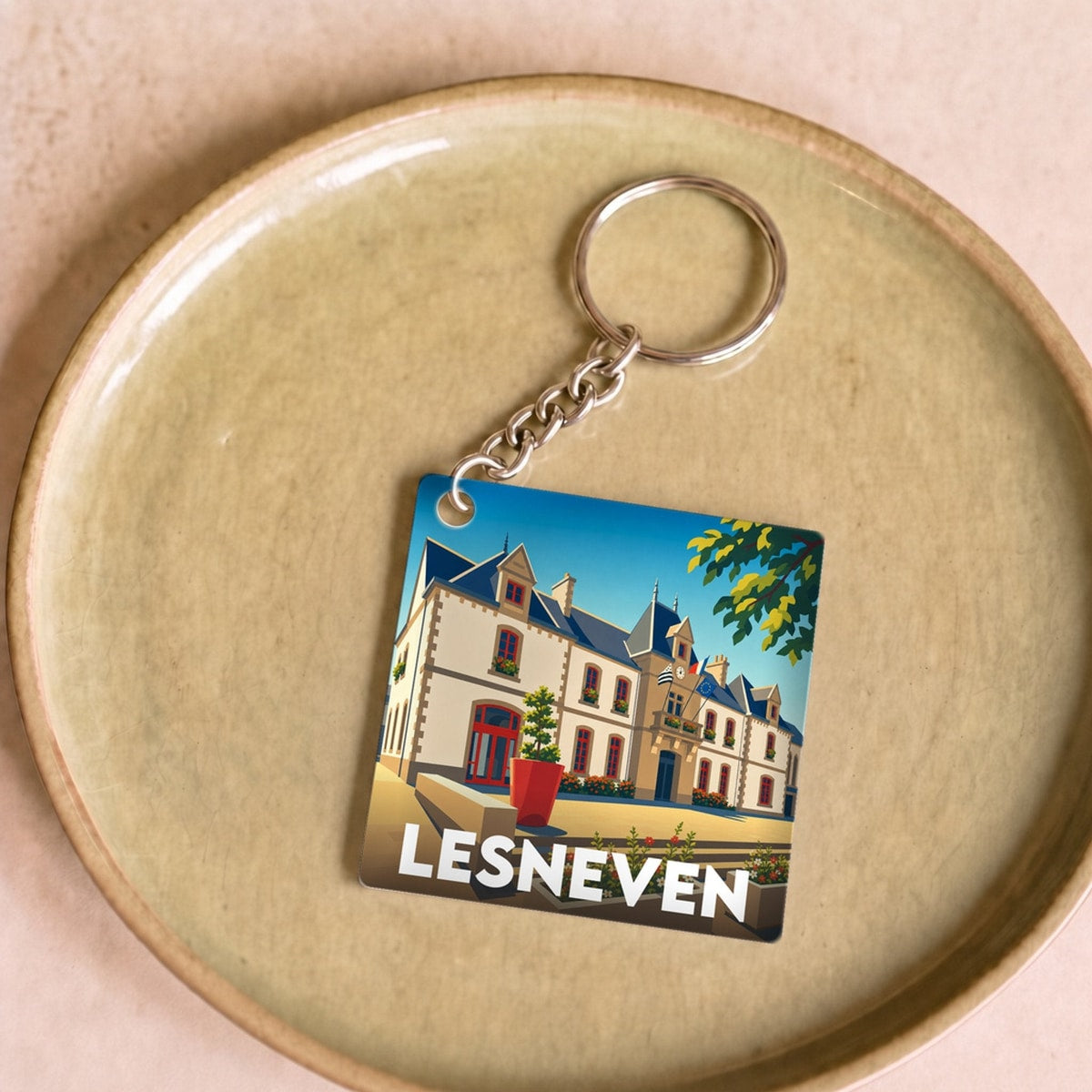 Porte-clés souvenir de la ville de Lesneven avec une illustration stylisée de son patrimoine.