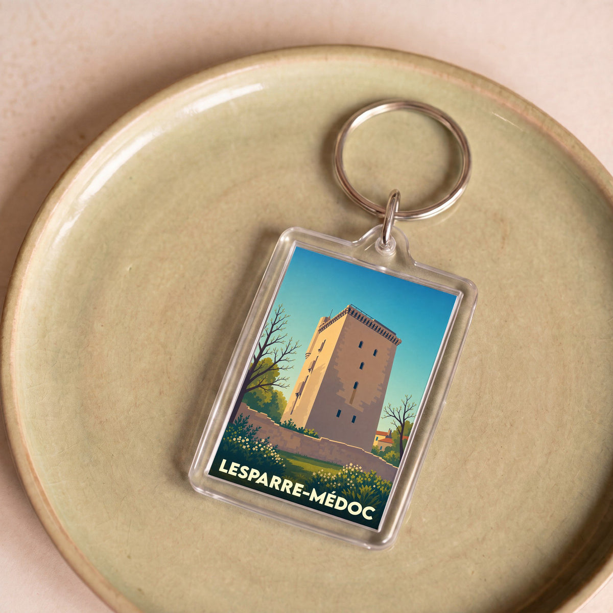 Porte-clés souvenir de la ville de Lesparre-Médoc avec une illustration stylisée de sa tour historique.