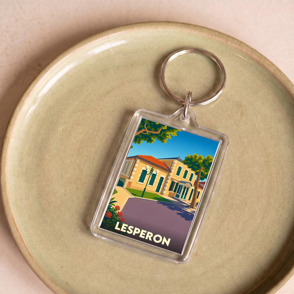 Porte-clés souvenir de la ville de Lesperon avec une illustration stylisée.