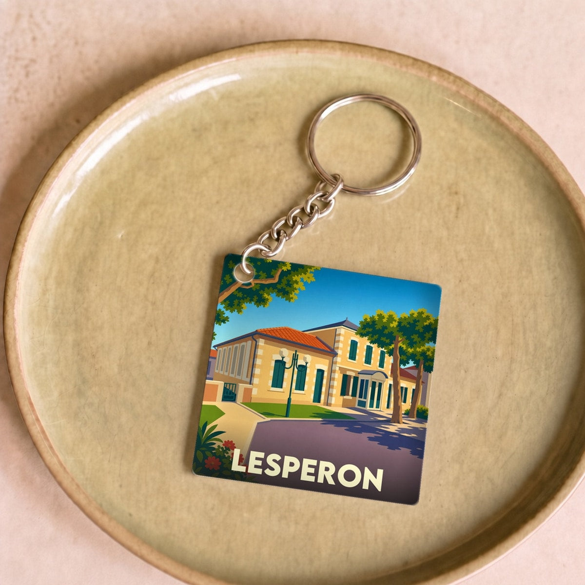 Porte-clés souvenir de la ville de Lesperon avec une illustration stylisée.