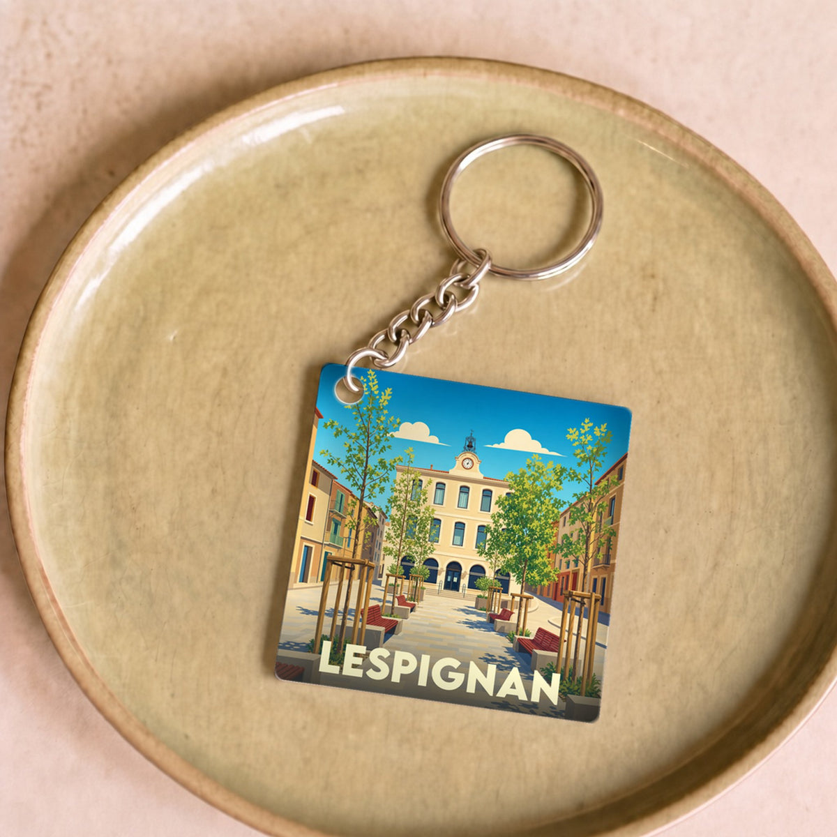 Porte-clés souvenir de la ville de Lespignan avec une illustration stylisée.