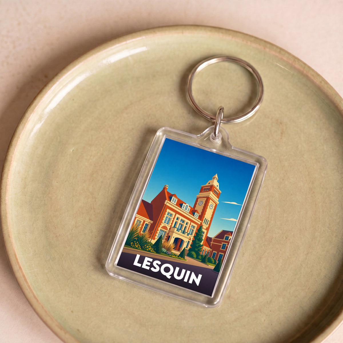 Porte-clés souvenir de la ville de Lesquin avec une illustration stylisée de son hôtel de ville.