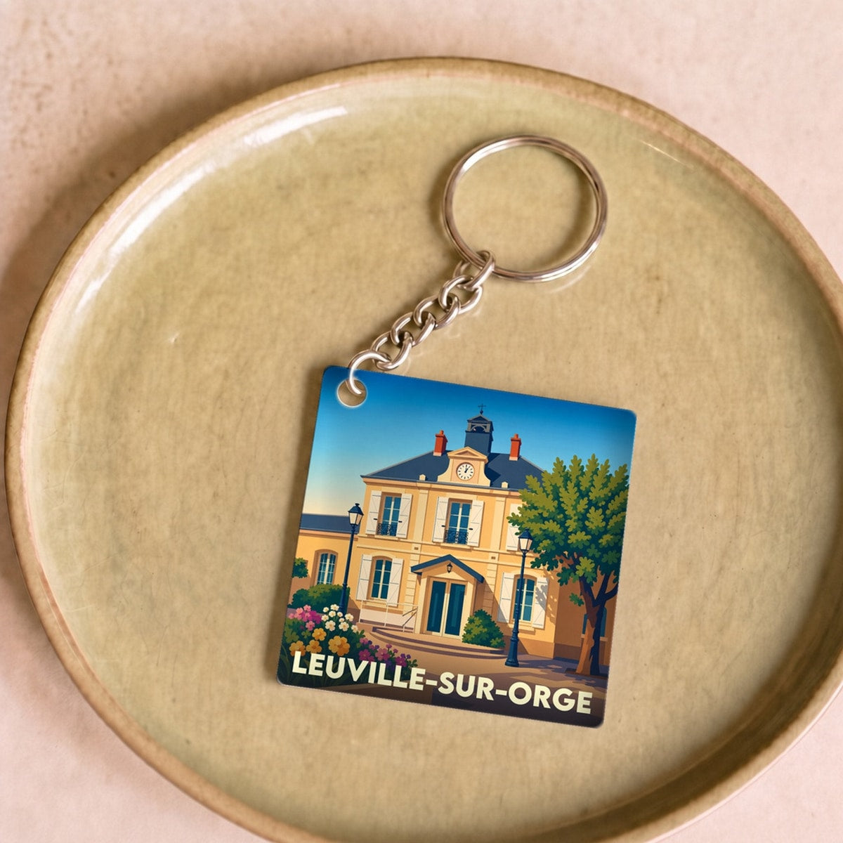 Porte-clés souvenir de la ville de Leuville-sur-Orge avec une illustration stylisée de la mairie.