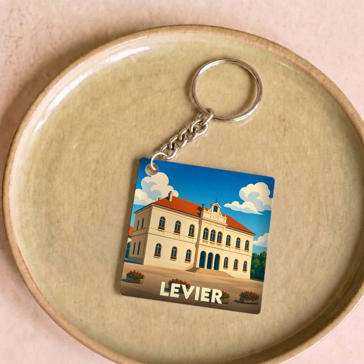 Porte-clés souvenir de la ville de Levier avec une illustration stylisée de son hôtel de ville.
