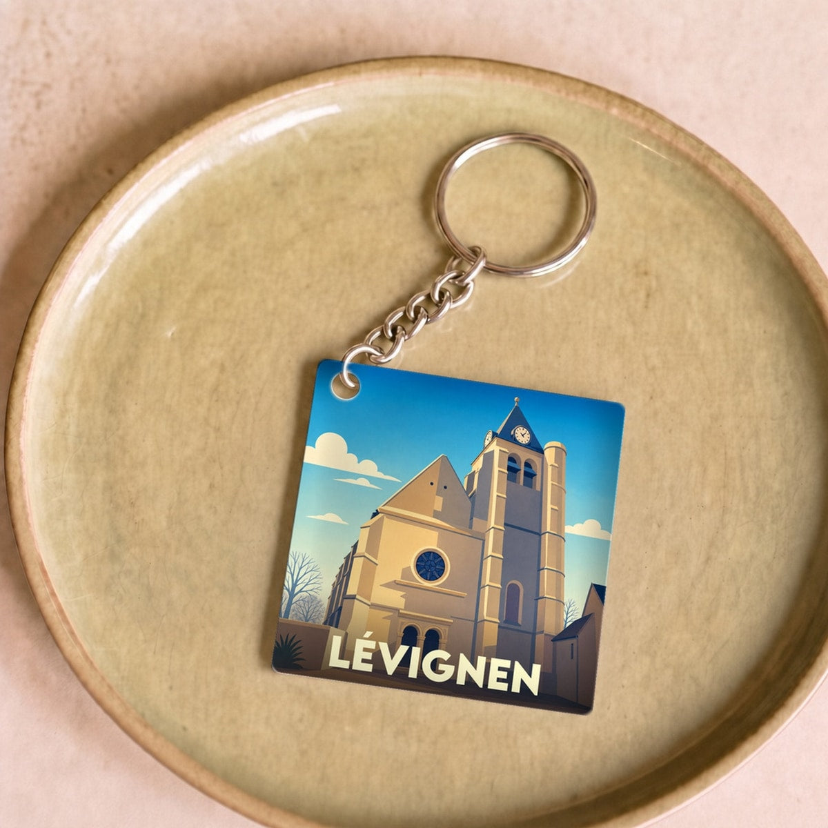 Porte-clés souvenir de la ville de Lévignen avec une illustration stylisée de son église.