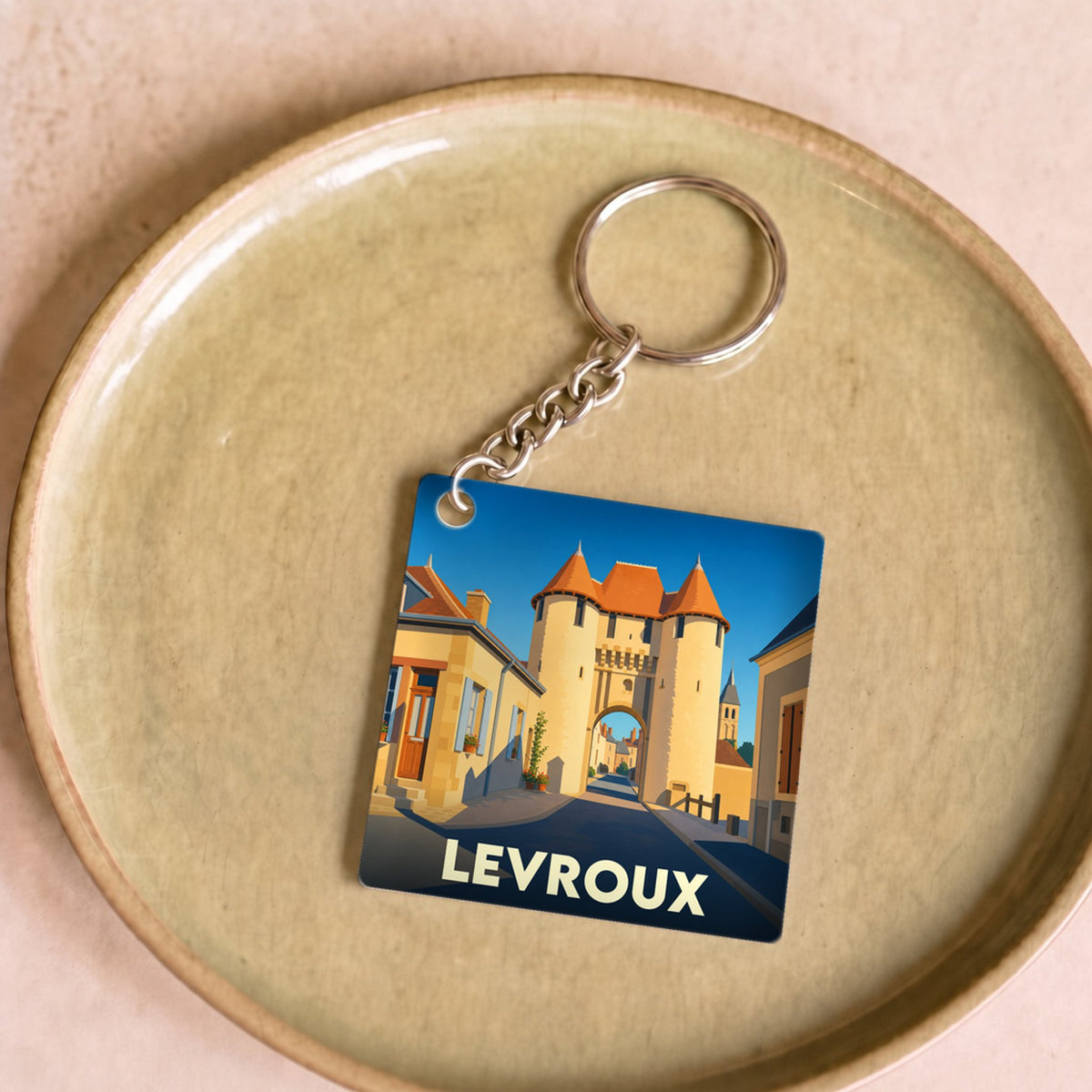 Porte-clés souvenir de la ville de Levroux avec une illustration stylisée de sa porte médiévale.