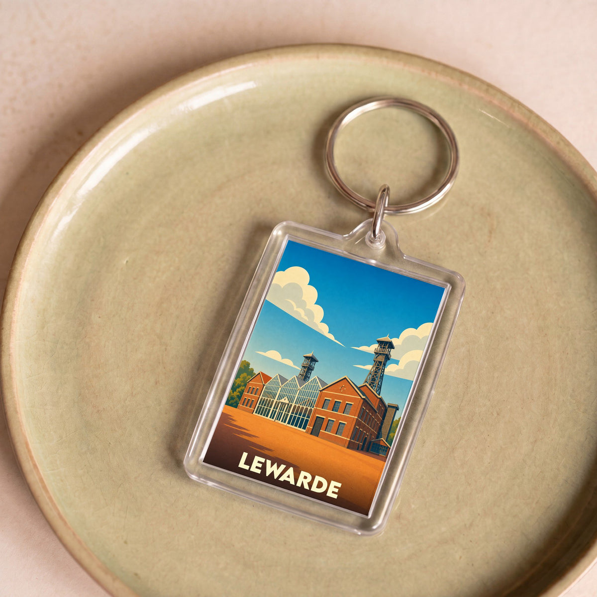 Porte-clés souvenir de la ville de Lewarde avec une illustration stylisée du centre historique minier.