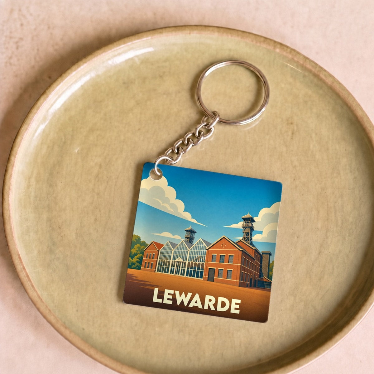 Porte-clés souvenir de la ville de Lewarde avec une illustration stylisée du centre historique minier.