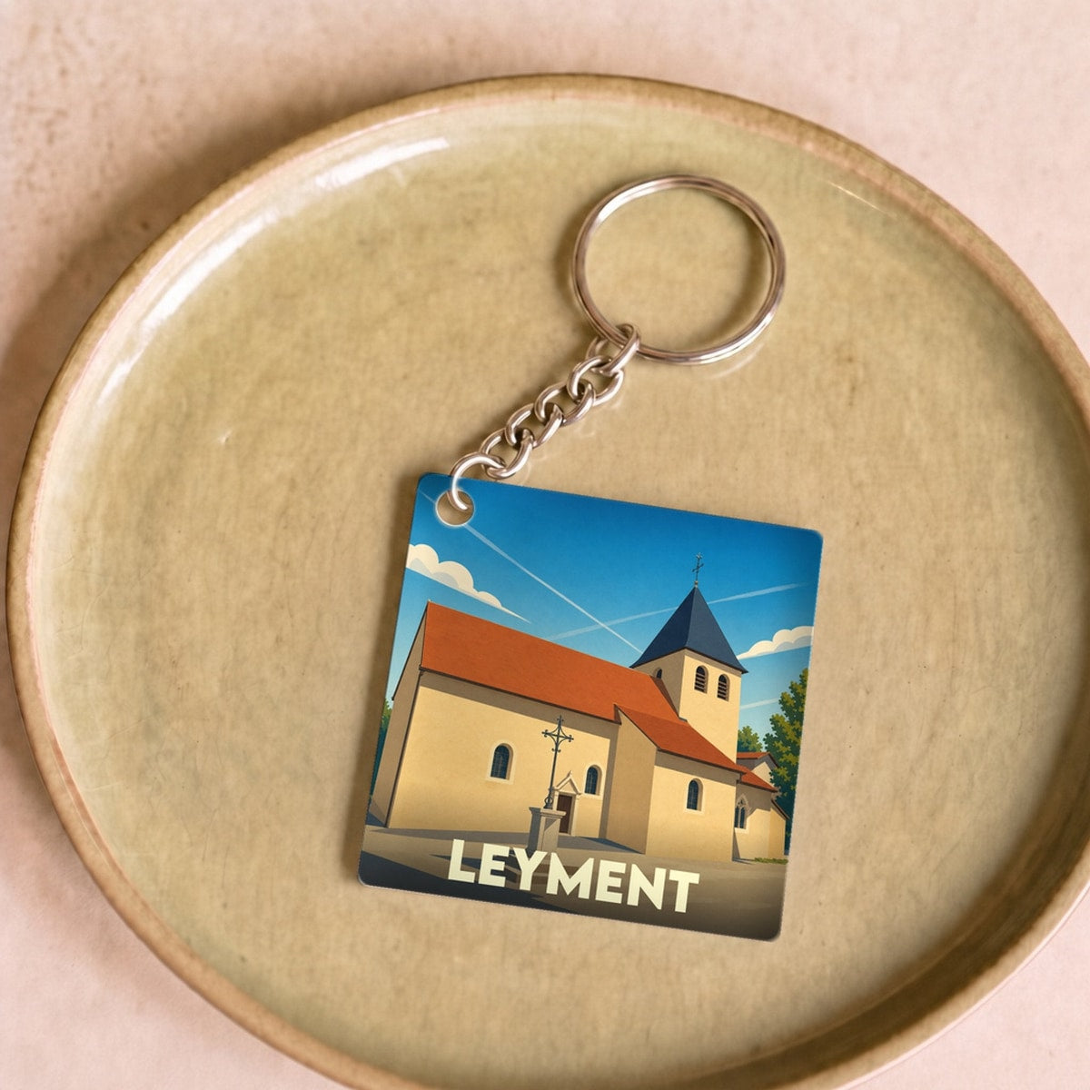 Porte-clés souvenir de la ville de Leyment avec une illustration stylisée de son église.