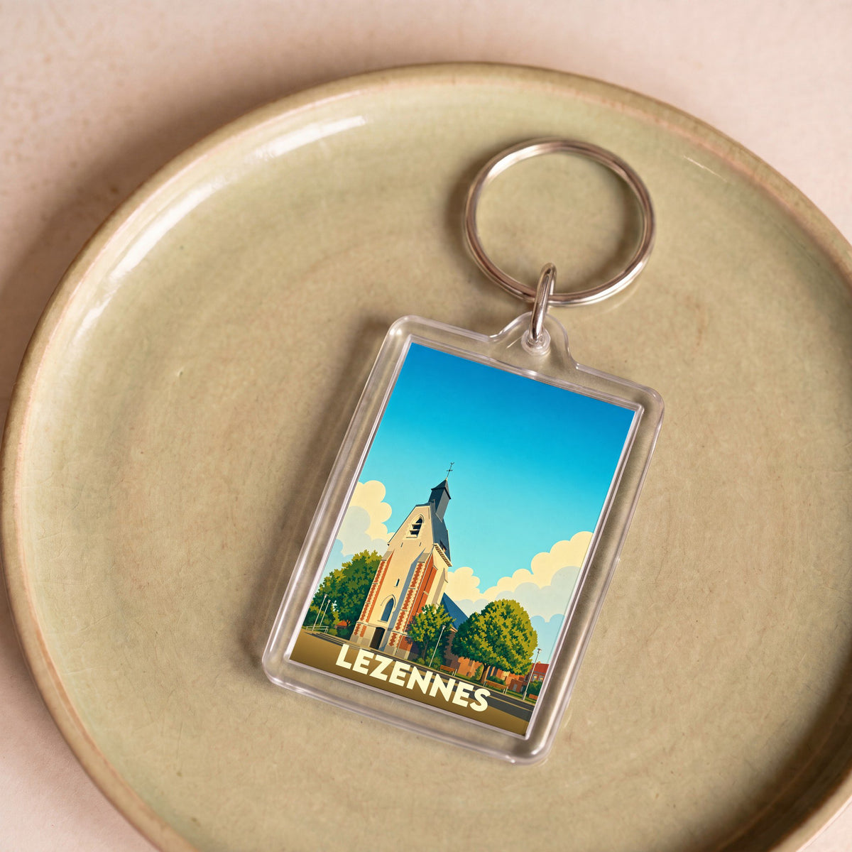 Porte-clés souvenir de la ville de Lezennes avec une illustration stylisée de son église.