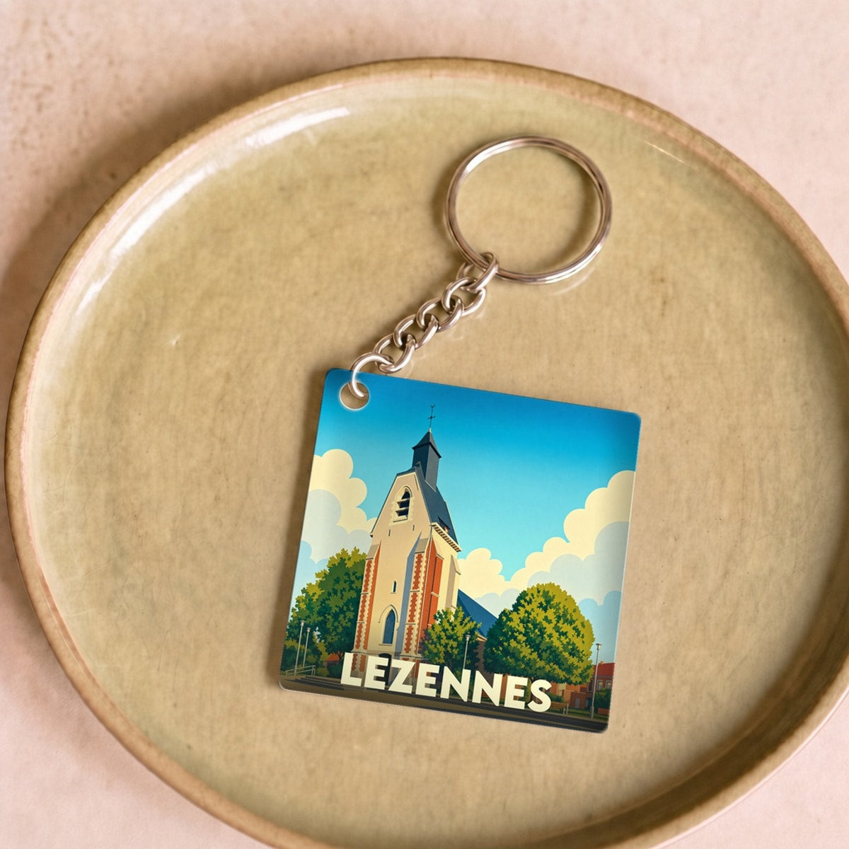 Porte-clés souvenir de la ville de Lezennes avec une illustration stylisée de son église.