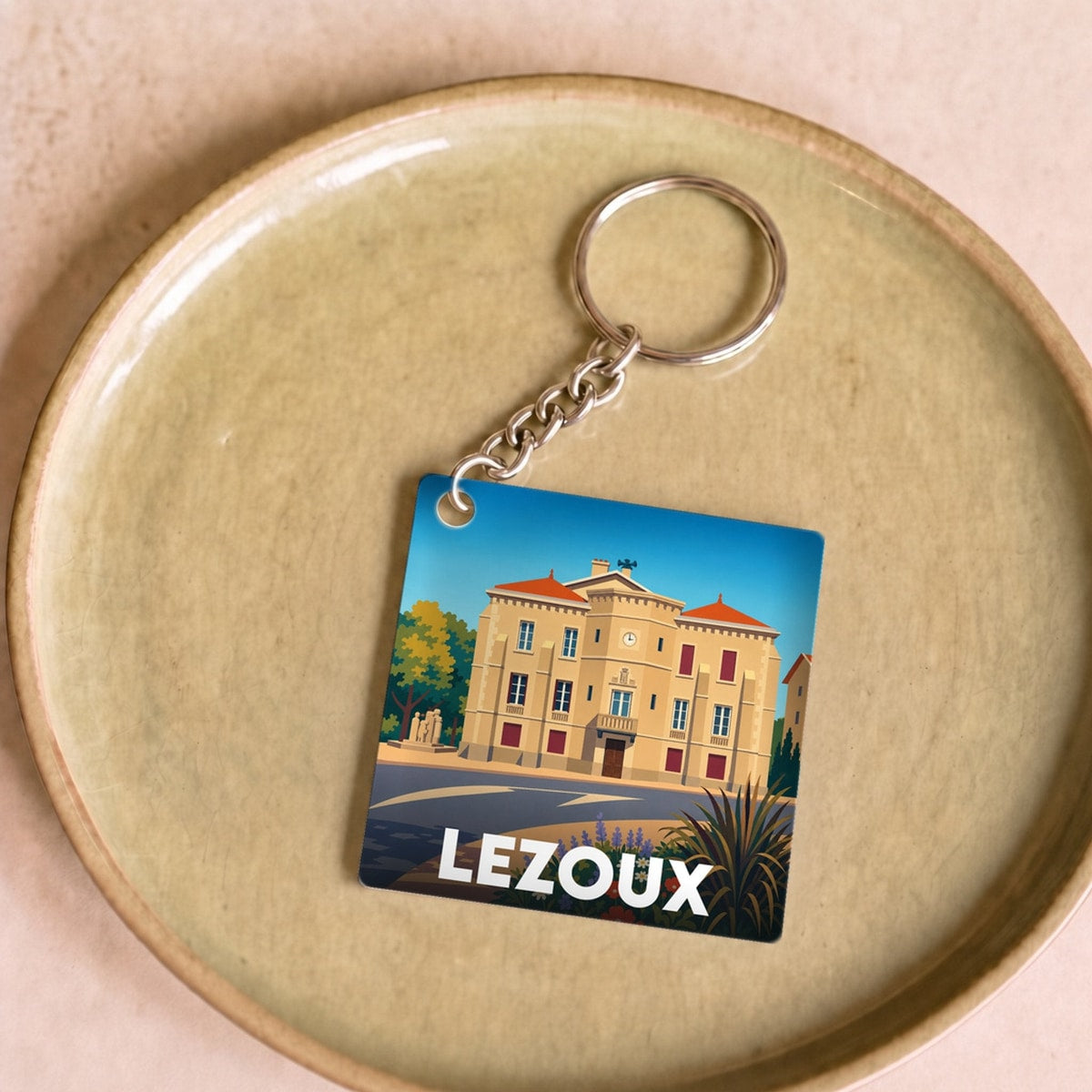 Porte-clés souvenir de la ville de Lezoux avec une illustration stylisée de son hôtel de ville.