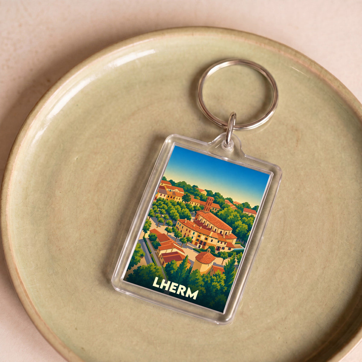 Porte-clés souvenir de la ville de Lherm avec une illustration stylisée.