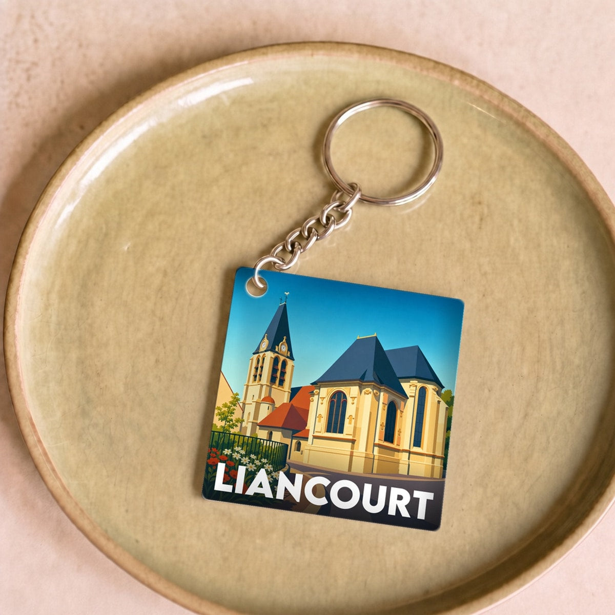Porte-clés souvenir de la ville de Liancourt avec une illustration stylisée de son église.