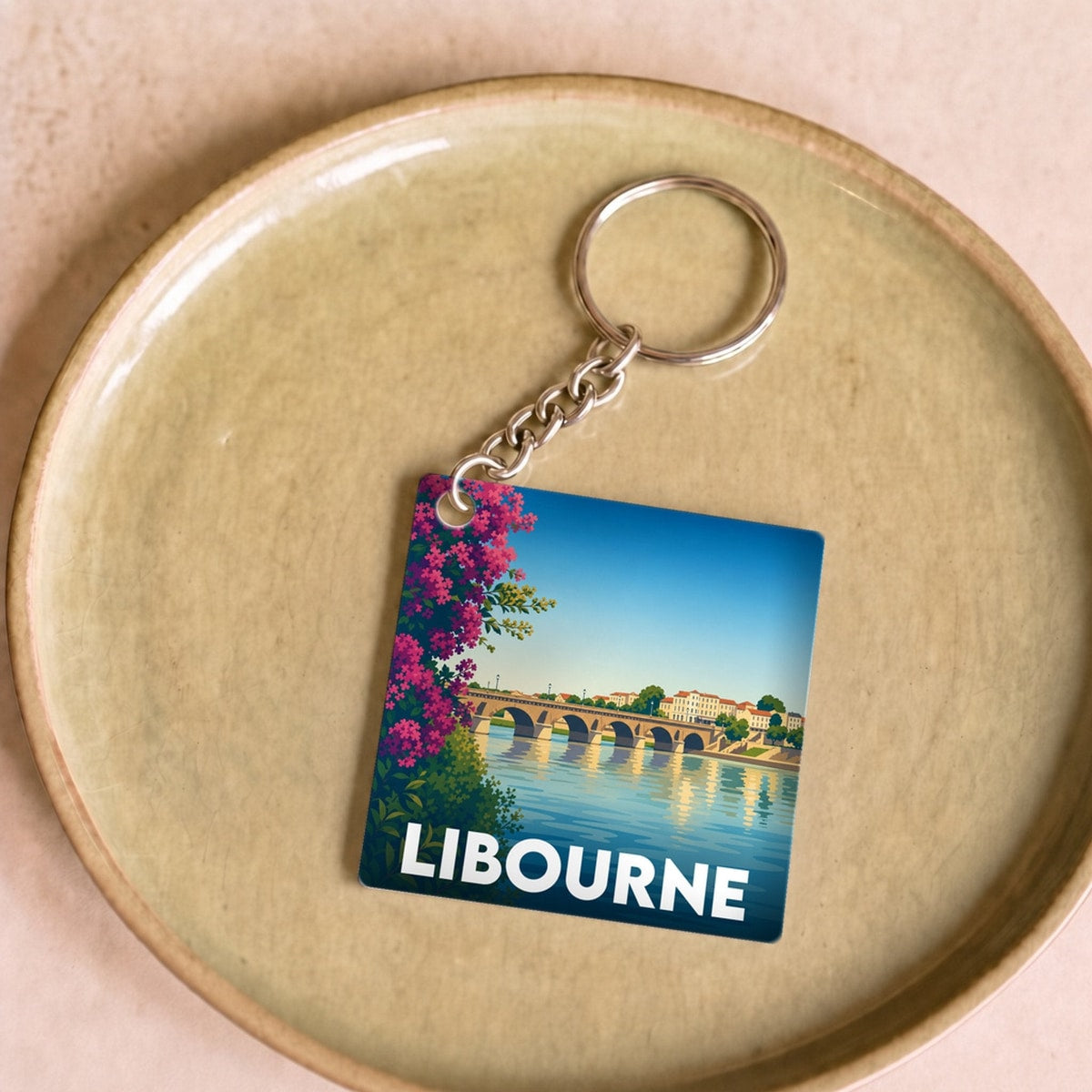 Porte-clés souvenir de la ville de Libourne avec une illustration stylisée d'un pont historique.