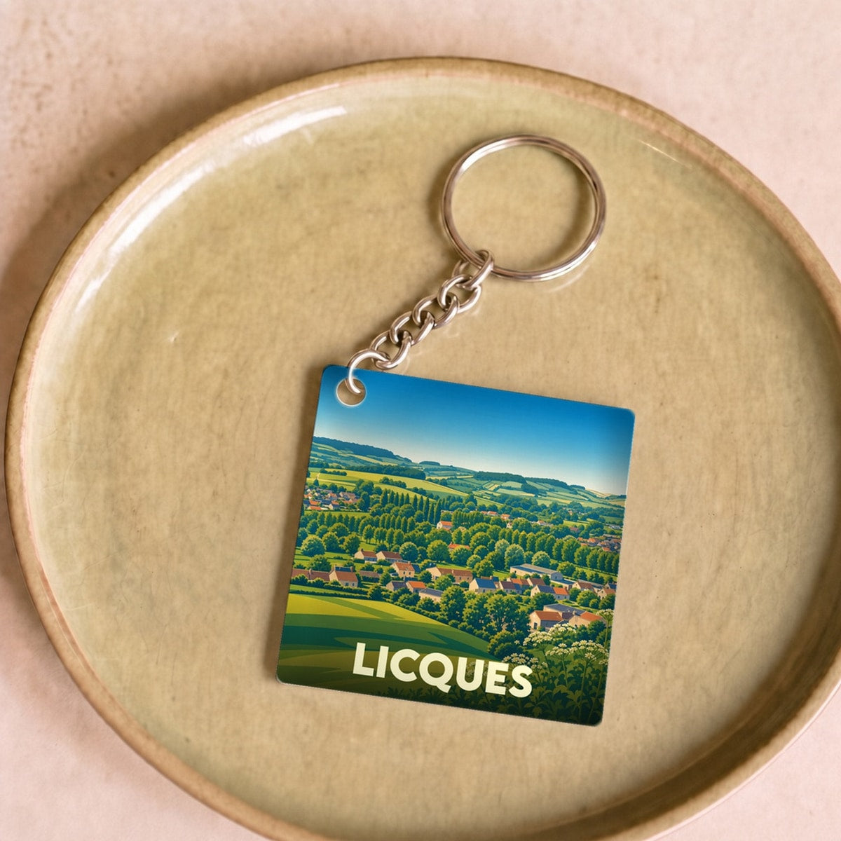 Porte-clés souvenir de la ville de Licques avec une illustration stylisée de son paysage vallonné.