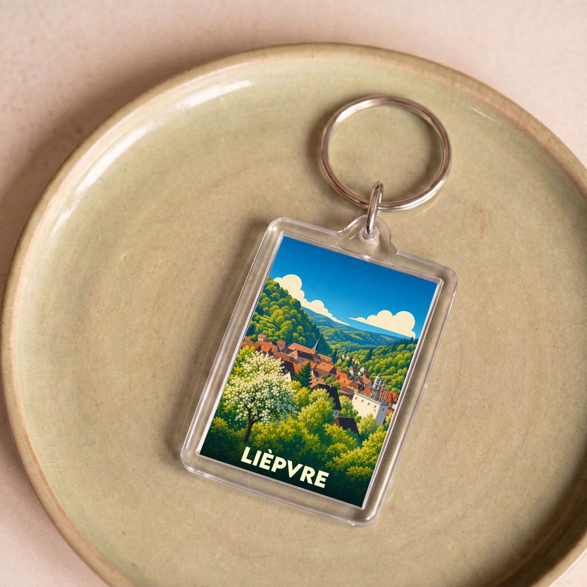 Porte-clés souvenir de la ville de Lièpvre avec une illustration stylisée.