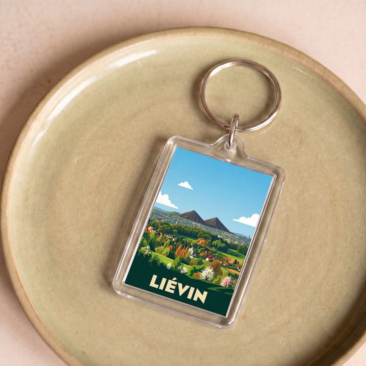 Porte-clés souvenir de la ville de Liévin avec une illustration stylisée.
