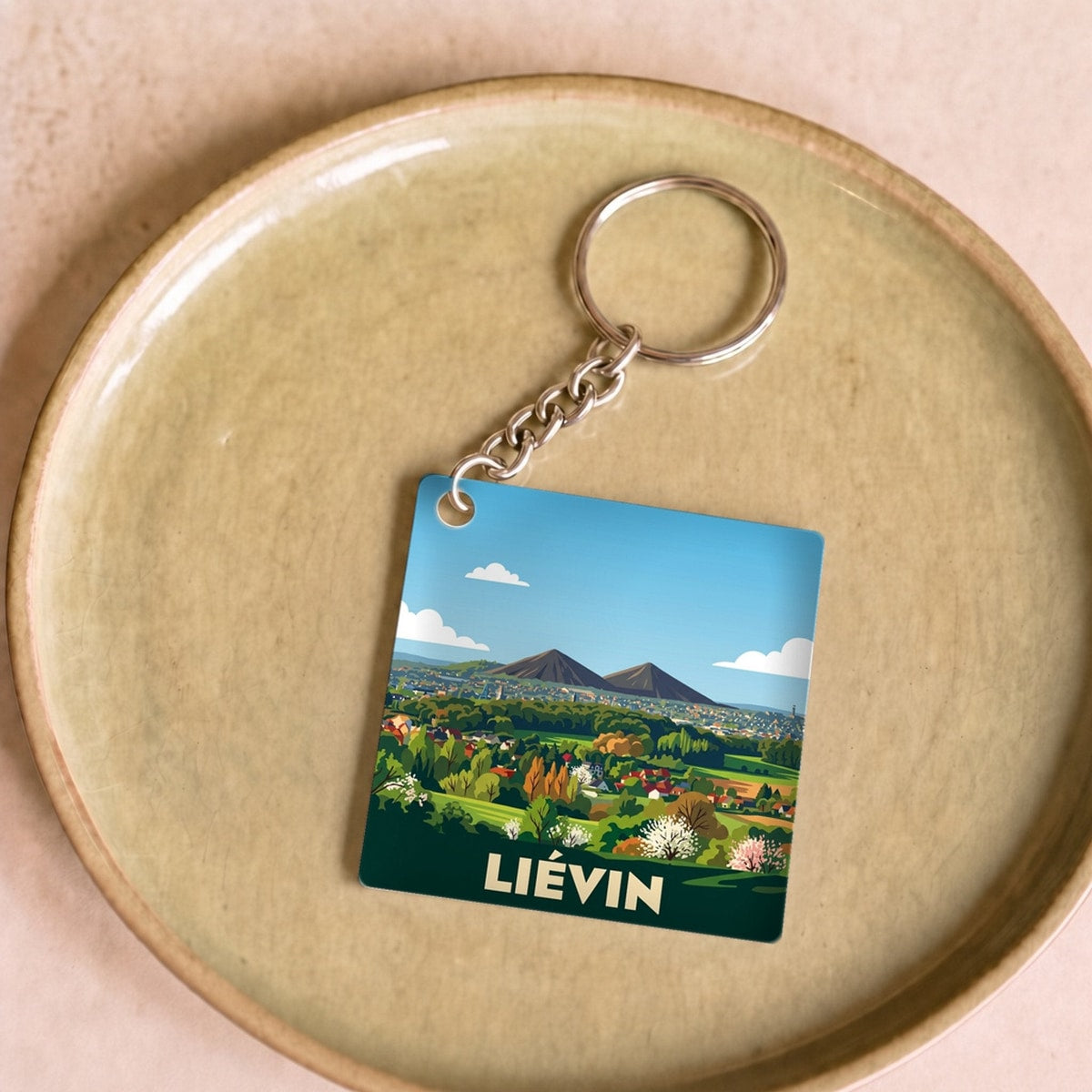 Porte-clés souvenir de la ville de Liévin avec une illustration stylisée.
