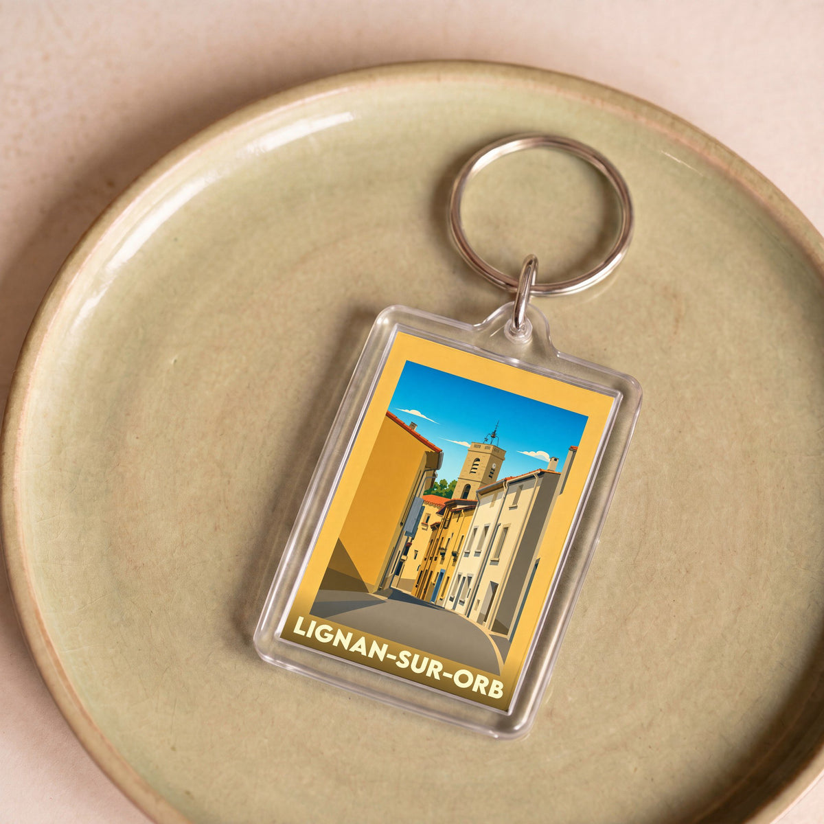 Porte-clés souvenir de la ville de Lignan-sur-Orb avec une illustration stylisée.