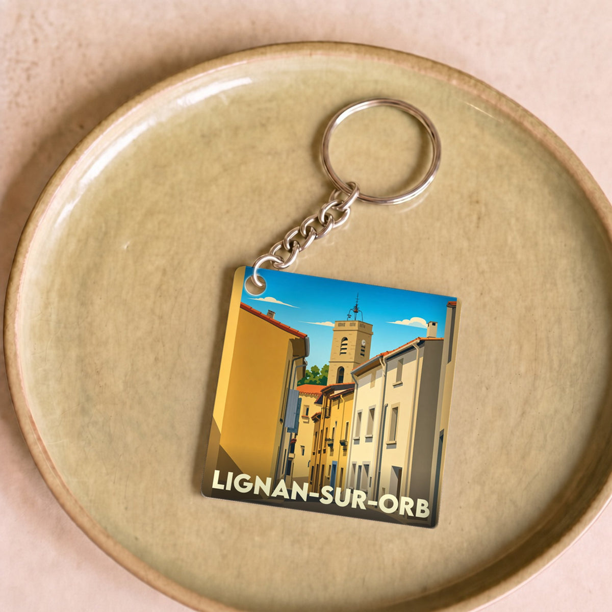 Porte-clés souvenir de la ville de Lignan-sur-Orb avec une illustration stylisée.