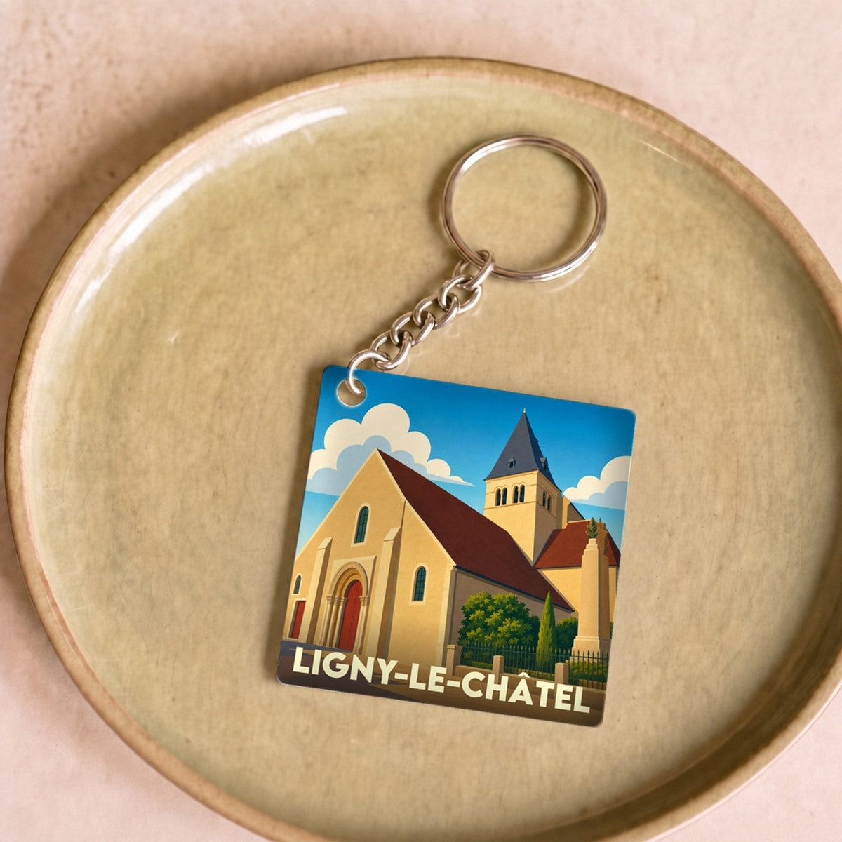 Porte-clés souvenir de la ville de Ligny-le-Châtel avec une illustration stylisée de son église.