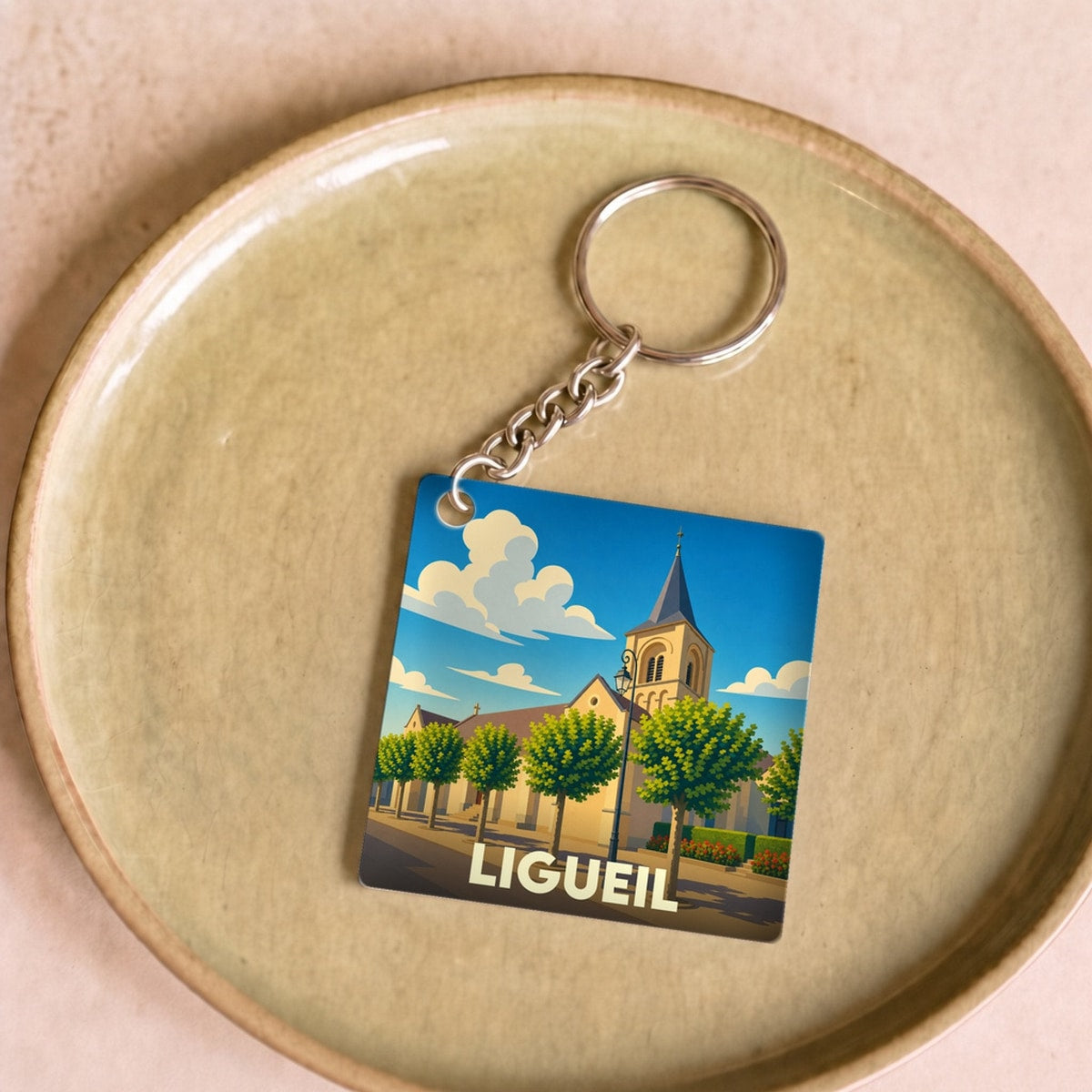 Porte-clés souvenir de la ville de Ligueil avec une illustration stylisée.