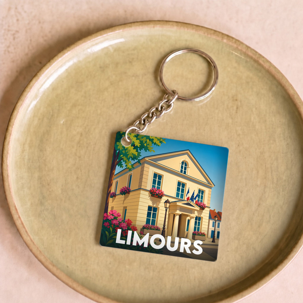 Porte-clés souvenir de la ville de Limours avec une illustration stylisée de son hôtel de ville.