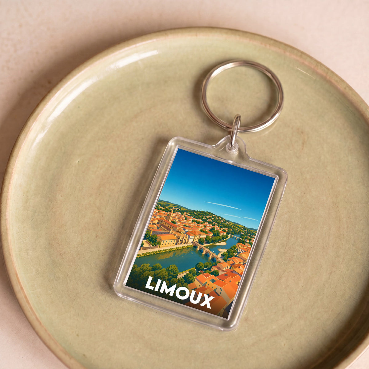 Porte-clés souvenir de la ville de Limoux avec une illustration stylisée.