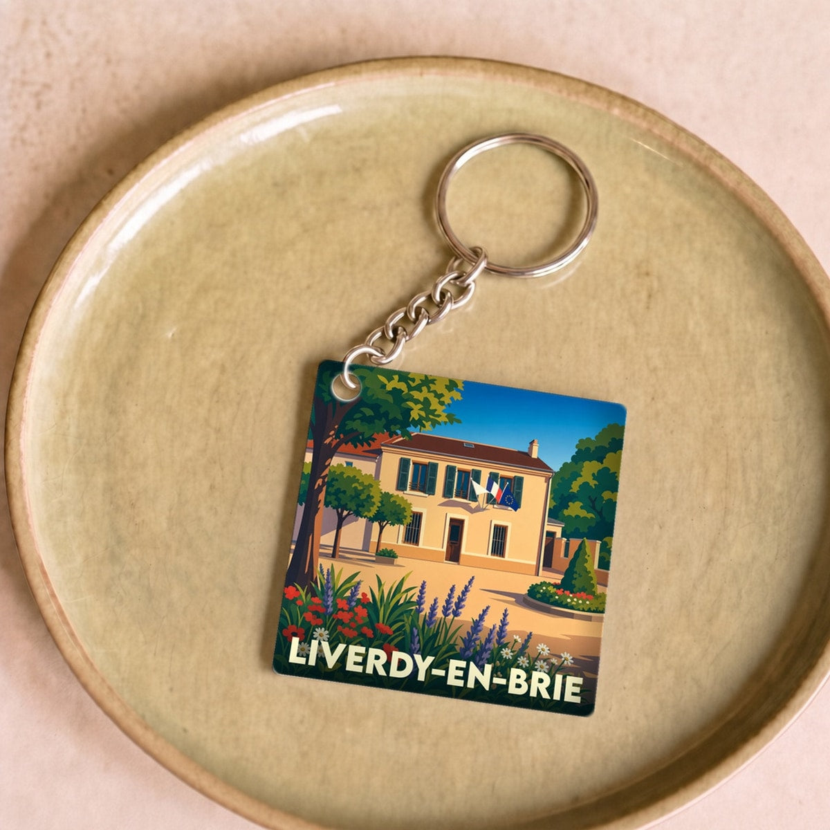 Porte-clés souvenir de la ville de Liverdy-en-Brie avec une illustration stylisée de sa mairie fleurie.