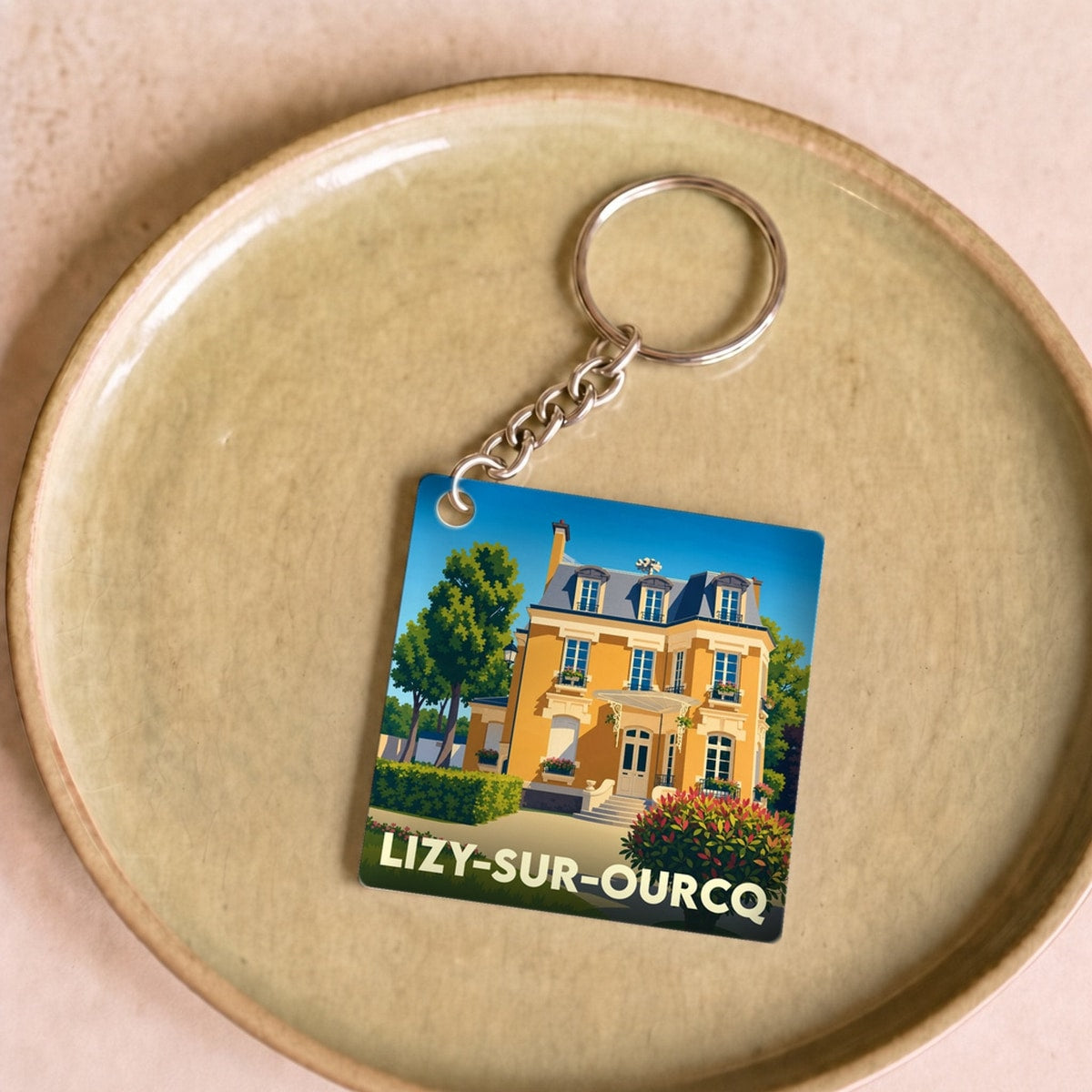Porte-clés souvenir de la ville de Lizy-sur-Ourcq avec une illustration stylisée d'une demeure bourgeoise.