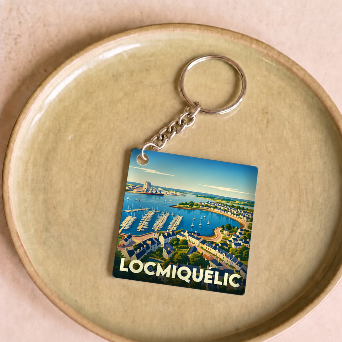 Porte-clés souvenir de la ville de Locmiquélic avec une illustration stylisée du port et de ses environs.
