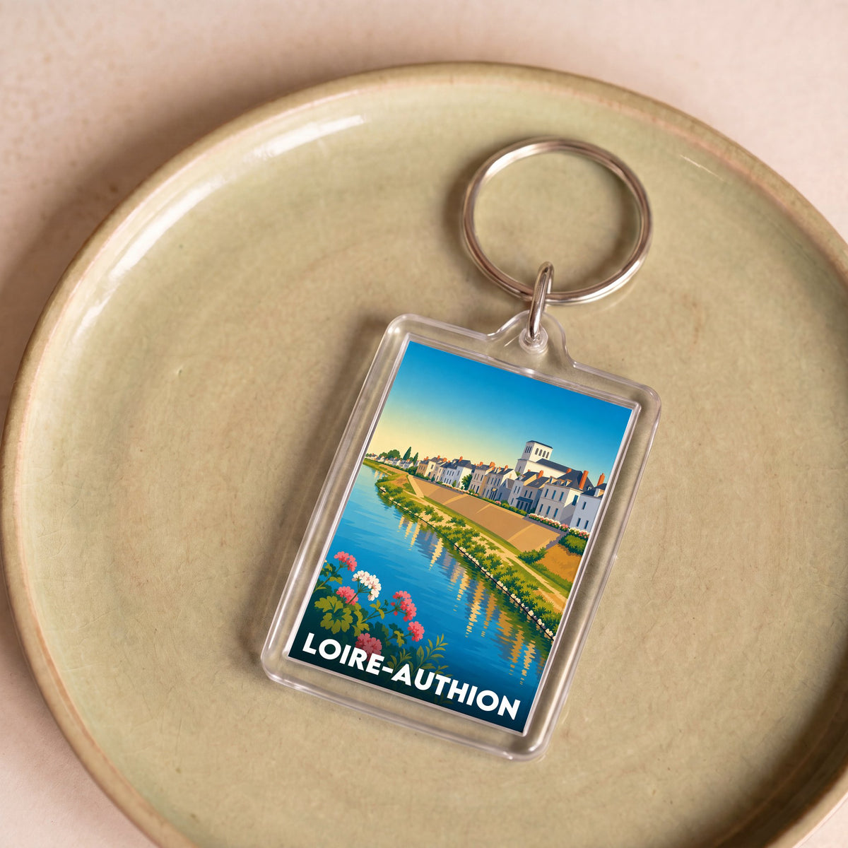Porte-clés souvenir de la ville de Loire-Authion avec une illustration stylisée.