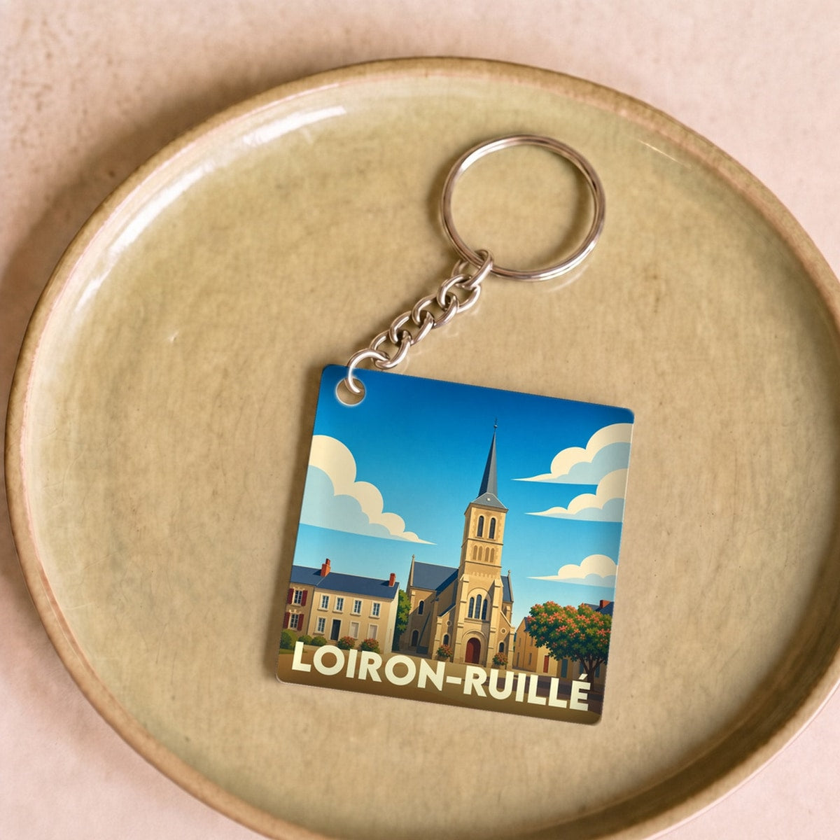 Porte-clés souvenir de la ville de Loiron-Ruillé avec une illustration stylisée de son église.