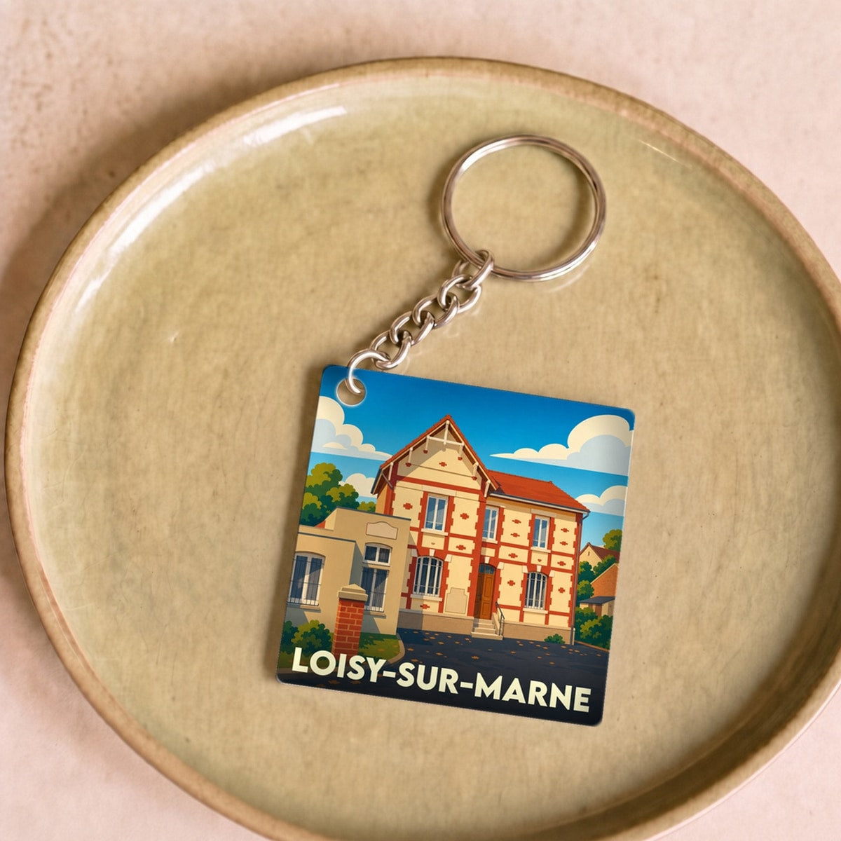 Porte-clés souvenir de la ville de Loisy-sur-Marne avec une illustration stylisée d'une maison traditionnelle.