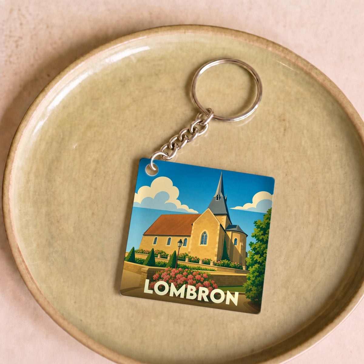Porte-clés souvenir de la ville de Lombron avec une illustration stylisée de son église.