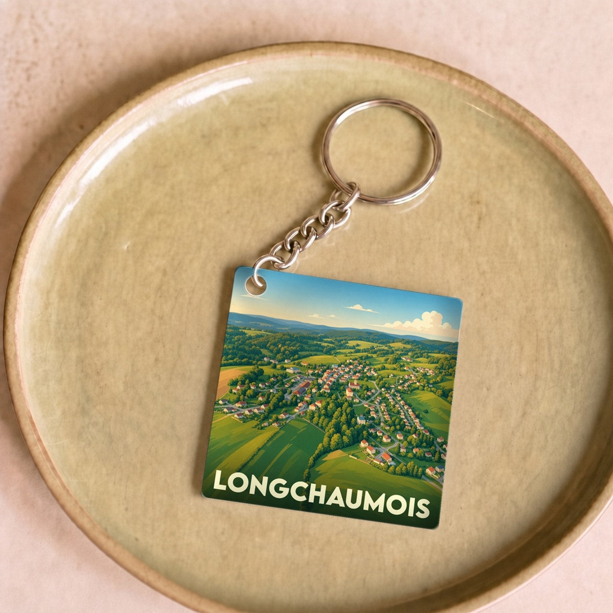 Porte-clés souvenir de la ville de Longchaumois avec une vue aérienne illustrée du village.