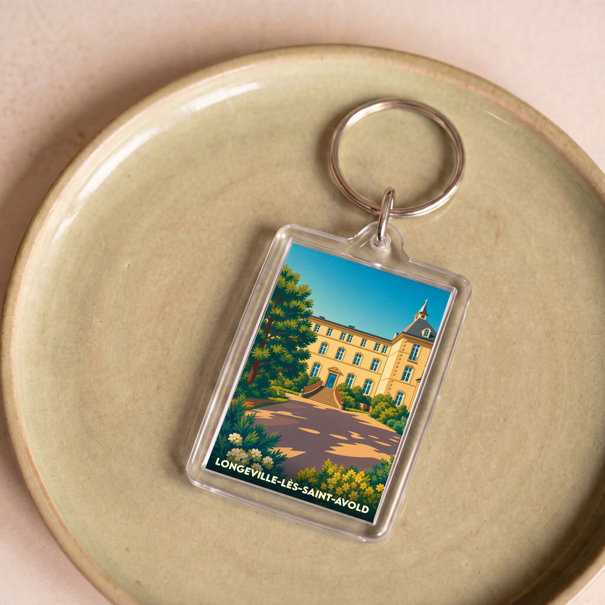 Porte-clés souvenir de la ville de Longeville-lès-Saint-Avold avec une illustration stylisée d'un bâtiment historique.
