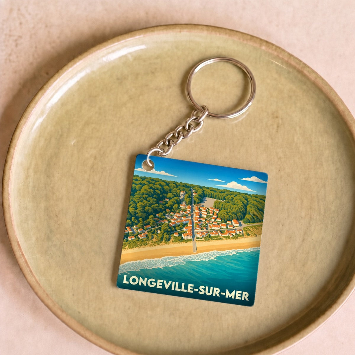 Porte-clés souvenir de Longeville-sur-Mer avec une illustration stylisée du bord de mer et du village.
